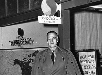 Howard Scott, Technocracy leader, poses in front of a sign.