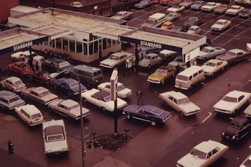 An American gas station in 1973, with a long line of cars.